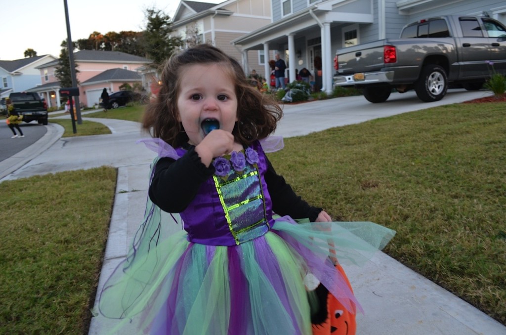 Girl with sucker trick or treating 