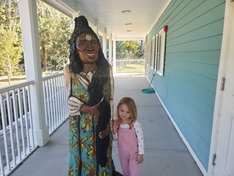 girl with folk art statue